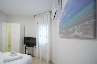 a bedroom with a bed and a painting on the wall at Jardines de Candelaria Cadiz in Cádiz