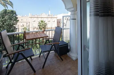 a balcony with two chairs and a table on a balcony at Jardines de Candelaria Cadiz in Cádiz