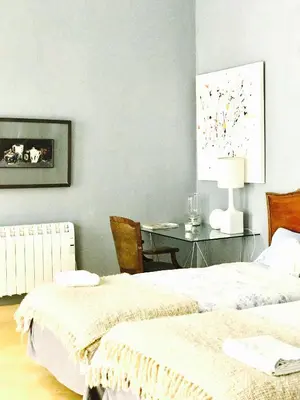 a bedroom with two beds and a table with a lamp at Casa Bolsa43 in Sanlúcar de Barrameda
