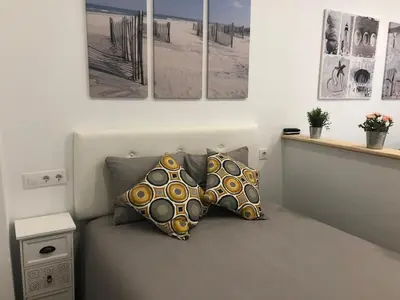 a room with three pillows on a bed with pictures on the wall at 'Sweet home' Loft con piscina en la mejor playa de El Puerto in El Puerto de Santa María