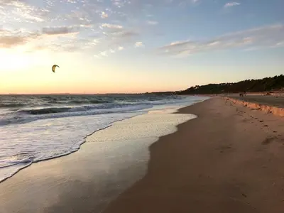 a person is flying a kite on the beach at 'Sweet home' Loft con piscina en la mejor playa de El Puerto in El Puerto de Santa María