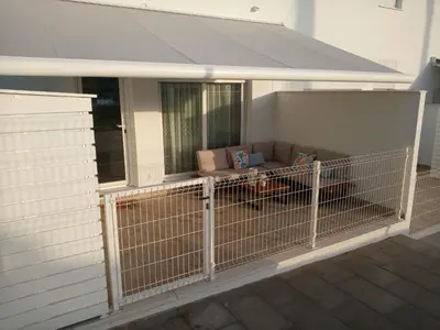 a screened in porch with a couch behind a fence at Enjoy Selecta Conil in Conil de la Frontera