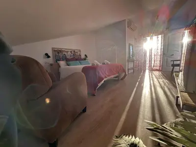 a bedroom with a bed and a sun shining through a window at Alojamiento Magallanes in Sanlúcar de Barrameda