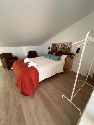 a bedroom with a bed with red and green pillows at Alojamiento Magallanes in Sanlúcar de Barrameda