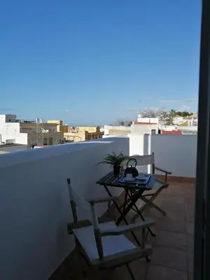 a table and two chairs sitting on a balcony at Alojamiento Magallanes in Sanlúcar de Barrameda