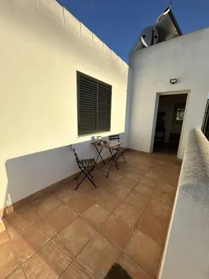 a patio with a table and a window on a building at Alojamiento Magallanes in Sanlúcar de Barrameda
