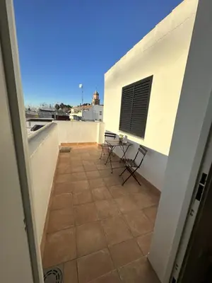a balcony with a table and chairs on a building at Alojamiento Magallanes in Sanlúcar de Barrameda