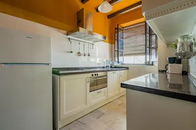 a kitchen with white cabinets and a white refrigerator at Apartamento Historico Garaje y WIFI in Sanlúcar de Barrameda