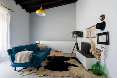 a living room with a blue couch and a table at Apartamento Historico Garaje y WIFI in Sanlúcar de Barrameda