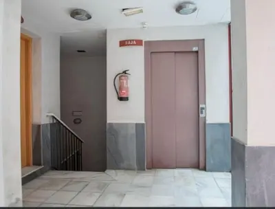 a door in a building with a fire hydrant on the wall at LA MÁS COQUETA, EN EL ADN DE CADIZ, in Cádiz