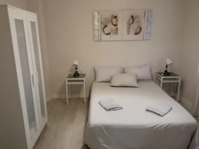 a bedroom with a white bed with two night stands at PISO PLAZA CABECEO in Jerez de la Frontera