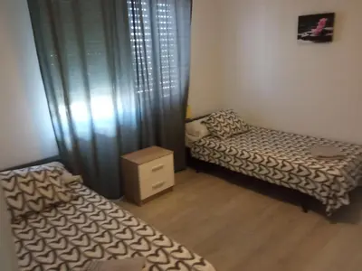 a small room with two beds and a window at PISO PLAZA CABECEO in Jerez de la Frontera