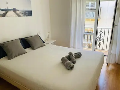 a bedroom with a large bed with two towels on it at Ático Cádiz Centro in Cádiz