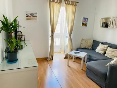 a living room with a blue couch and a table at Ático Cádiz Centro in Cádiz