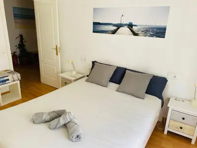 a white bed in a room with a picture on the wall at Ático Cádiz Centro in Cádiz