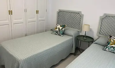 a bedroom with two beds and a table with a lamp at NOVO SANCTI PETRI - CASA CON ENCANTO in Novo Sancti Petri