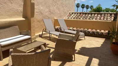 a patio with wicker chairs and chairs on a patio at NOVO SANCTI PETRI - CASA CON ENCANTO in Novo Sancti Petri