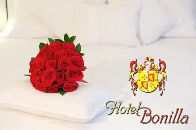 a bouquet of red roses sitting on a bed at Hotel Bonilla in La Barca de la Florida