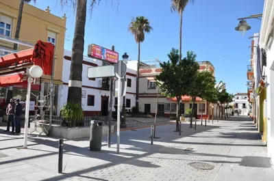 a street in a city with palm trees and buildings at Villachipi in Chipiona