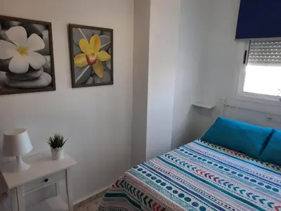 a small bedroom with a bed and a window at Villachipi in Chipiona