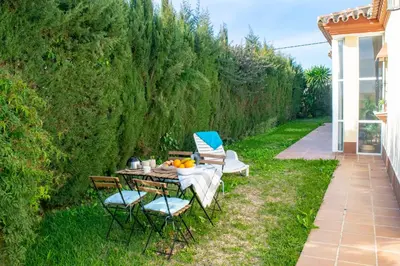 a table and chairs on a lawn with a hedge at Villa Elissa with 3 bedrooms andpool and views close to Conil in Cádiz