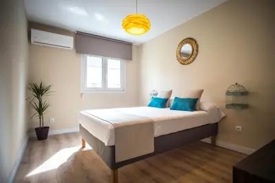 a bedroom with a large bed with blue pillows at Santo Tomás A Ha Apartment in Cádiz