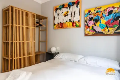 a bedroom with a bed and a painting on the wall at Casa Arcoiris by Cadiz Time in Cádiz
