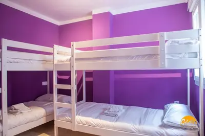 two bunk beds in a room with purple walls at Casa Arcoiris by Cadiz Time in Cádiz