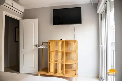 a room with a television on a wall with a book shelf at Casa Arcoiris by Cadiz Time in Cádiz