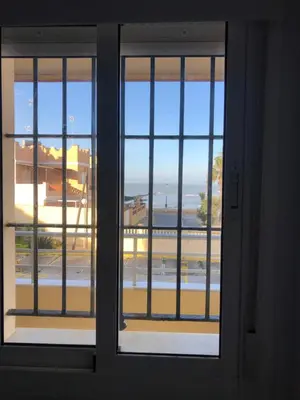a room with two beds and a window at Faro de chipiona in Chipiona