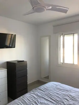 a bedroom with a bed and a ceiling fan at Faro de chipiona in Chipiona