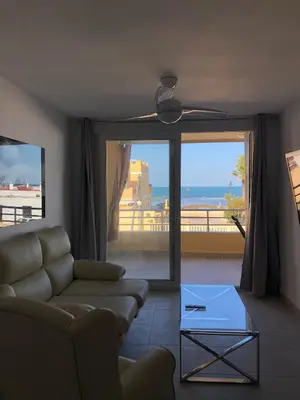 a living room with a couch and a view of the ocean at Faro de chipiona in Chipiona