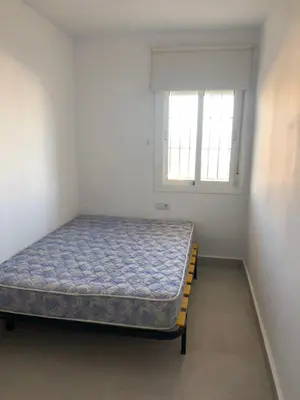 a bed in a room with a window at Faro de chipiona in Chipiona