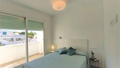 a bedroom with a bed and a large window at La Fontanilla Place in Conil de la Frontera
