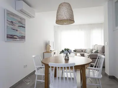 a white living room with a table and chairs at La Fontanilla Place in Conil de la Frontera
