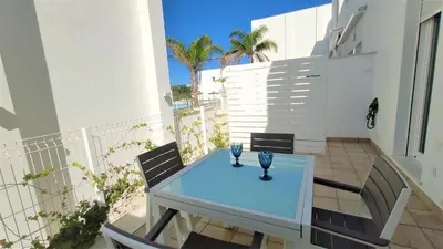 a glass table on a balcony with two vases on it at La Fontanilla Place in Conil de la Frontera