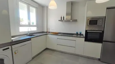a white kitchen with a sink and a microwave at La Fontanilla Place in Conil de la Frontera