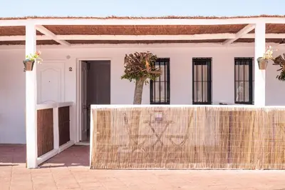 a fence in front of a white house with windows at Hotel Marhava in Conil de la Frontera