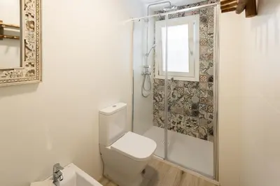 a white bathroom with a toilet and a shower at Apartamento Entrecatedrales in Cádiz