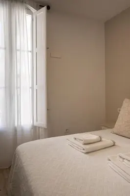 a bedroom with a bed with two towels on it at Apartamento Entrecatedrales in Cádiz