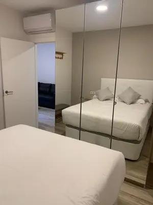 a bedroom with two beds and a mirror at Apartamento Entrecatedrales 2 in Cádiz
