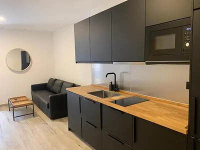 a kitchen with a sink and a couch in a room at Apartamento Entrecatedrales 2 in Cádiz