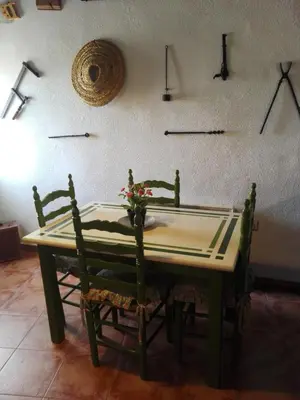 a table with two chairs and a vase of flowers on it at Casa Museo Jerez Centro in Jerez de la Frontera