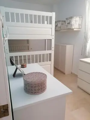a white room with a bunk bed and a table at Apartamento Ailem in Novo Sancti Petri