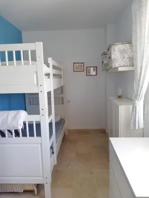 a bedroom with a bunk bed and a white bunk ladder at Apartamento Ailem in Novo Sancti Petri