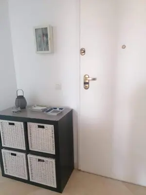 a room with a door and a table with baskets at Apartamento Ailem in Novo Sancti Petri