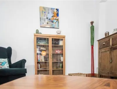 a living room with a table and a book shelf at APARTAMENTO LA MODERNA in Cádiz