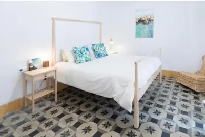a bedroom with a large white bed and a table at APARTAMENTO LA MODERNA in Cádiz