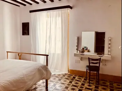 a bedroom with a bed and a desk and a window at APARTAMENTO LA MODERNA in Cádiz