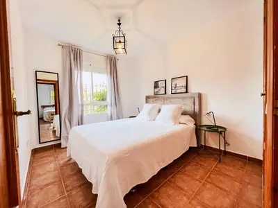 a bedroom with a white bed and a window at Jardín del Golf Nº 36 by Fontanilla del Mar Holidays Rentals in Chiclana de la Frontera